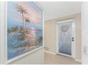 Hallway with beach-themed art and door to patio at 9900 Fiddlers Green Cir # 137, Rotonda West, FL 33947