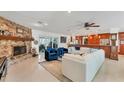 Open living room with white sectional sofa, blue armchairs, and stone fireplace at 1080 Bayshore Dr, Englewood, FL 34223