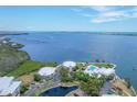 Stunning aerial view of waterfront homes, a pool, and a scenic bay at 11000 Placida Rd # 101, Placida, FL 33946