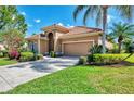 Well-maintained home with a terracotta roof, tidy landscaping, and a double garage on a sunny day at 13347 Golf Pointe Dr, Port Charlotte, FL 33953