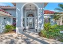 Close-up of front entrance showing arched doorway and glass front door with manicured landscaping at 14429 Bridgeview Ln, Port Charlotte, FL 33953