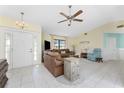 Bright living room features tile floors, a ceiling fan, comfortable seating, and plenty of natural light at 15524 Ruston Cir, Port Charlotte, FL 33981