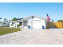 Inviting single-story home featuring a well-kept lawn, screen porch, and an attached garage at 1586 Overbrook Rd, Englewood, FL 34223