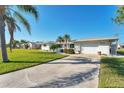 Well-maintained single-story home with a two-car garage, lush lawn, and inviting curb appeal at 1710 Loralin Dr, Englewood, FL 34223