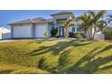 Inviting single Gathering home with a well-manicured lawn, an attached two-car garage, and tasteful landscaping at 18502 Arapahoe Cir, Port Charlotte, FL 33948