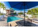 Inviting pool area with patio furniture and a view of a nearby building with balconies at 2375 N Beach Rd # 2B, Englewood, FL 34223