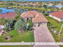 Expansive single-Gathering home showing the meticulously maintained yard, tile roof, and the beautiful lake behind the property at 2660 Sable Palm Way, Port Charlotte, FL 33953