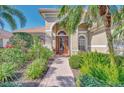 Inviting front entrance featuring a brick walkway and lush landscaping at 2660 Sable Palm Way, Port Charlotte, FL 33953