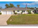 Inviting single-story home with a neat lawn and a charming American flag display at 3204 Depew Ave, Port Charlotte, FL 33952