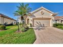 Well-maintained home features a two-car garage, lush landscaping, and a welcoming facade at 3307 Osprey Ln, Port Charlotte, FL 33953