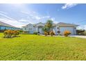 Inviting home featuring a well-kept lawn, a variety of plants and an attached two car garage at 39 Medalist Cir, Rotonda West, FL 33947