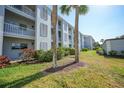 Condo building exterior with landscaping and palm trees at 404 Cerromar N Cir # 112, Venice, FL 34293