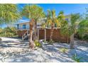 Two-story home with expansive deck and tropical landscaping at 5 Pointe Way, Placida, FL 33946