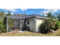 Backyard view showing a screened enclosure and landscaping at 6981 Tuxedo St, Englewood, FL 34224