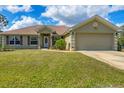 Attractive home featuring a manicured front lawn, complementary shutters, and an attached two-car garage at 8205 Chico St, Port Charlotte, FL 33981