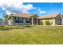 Charming home with a well-maintained lawn, neutral stucco, and a welcoming front entrance with decorative columns at 8205 Chico St, Port Charlotte, FL 33981