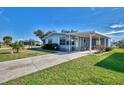 Well-maintained single story home with a covered carport and well maintained landscaping, green grass and blue skies at 8431 Nighthawk Dr, Englewood, FL 34224