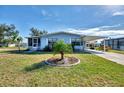 Charming single-story home with well-maintained landscaping, green grass and blue skies at 8431 Nighthawk Dr, Englewood, FL 34224