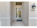Inviting front entrance showcasing glass front door, sconce, and clearly visible address number at 13241 Scrub Jay Ct, Port Charlotte, FL 33953