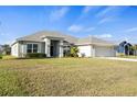 Charming single-Gathering home boasts a well-manicured lawn, light gray exterior paint, and a gray roof at 23 Fairway Rd, Rotonda West, FL 33947