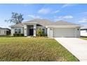 Well-maintained single-Gathering home with a light gray exterior, gray roof, and a spacious front lawn at 23 Fairway Rd, Rotonda West, FL 33947