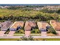 Overhead view of single-story home with red-tiled roof, brick driveway, and mature landscaping at 27413 Hole In One Pl, Englewood, FL 34223