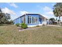 Quaint blue house featuring a well-kept lawn and large windows at 6347 Oriole Blvd, Englewood, FL 34224