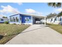 Charming blue home with a covered carport and well-maintained landscaping at 6347 Oriole Blvd, Englewood, FL 34224