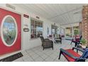 Relaxing covered porch featuring neutral tile flooring and comfortable seating for outdoor enjoyment at 6522 Coliseum Blvd, Port Charlotte, FL 33981