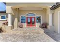 Covered front porch with a red double-door entrance and paved porch at 72 Pennant Ct, Placida, FL 33946