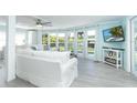 Airy living room boasts neutral tones, comfortable seating, and expansive windows with views of the pool at 8243 Pinetree Ln, Englewood, FL 34224