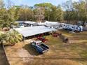Property showcasing a collection of outbuildings, equipment, and vehicles in a rural setting at 9094 Preston Rd, Brooksville, FL 34601