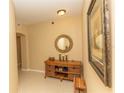 Inviting hallway features stylish decor with tiled floors, decorative table and accent mirror at 9203 Griggs Rd # 301, Englewood, FL 34224