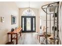 Inviting foyer featuring wood-look floors, decorative lighting and a beautiful front door at 118 Albatross Rd, Rotonda West, FL 33947