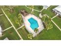 Aerial view of a community pool surrounded by palm trees and lush landscaping at 3220 Southfield Ln # 810, Sarasota, FL 34239