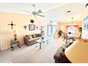 Bright living room featuring a vaulted ceiling, neutral carpet, ceiling fan, and an open floor plan at 501 Cobalt Rd, Englewood, FL 34223