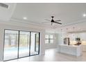 Open-concept living room connected to a modern kitchen, offering a view of the pool through expansive glass doors at 7282 Printer St, Port Charlotte, FL 33981