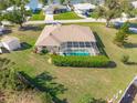 Aerial view of a home with a screened-in pool and a lush green backyard with room for entertaining at 7424 Snow Dr, Englewood, FL 34224