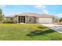 Well-kept single-story home with manicured lawn, two-car garage, and decorative front accents at 7424 Snow Dr, Englewood, FL 34224