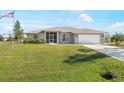 Charming single-story home with a well-maintained lawn and a two-car garage at 7424 Snow Dr, Englewood, FL 34224