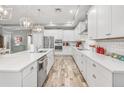 Modern kitchen with white cabinets, stainless steel appliances, and tile flooring at 813 Old Windsor Way, Spring Hill, FL 34609