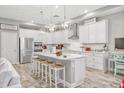 Spacious kitchen featuring white cabinets, stainless steel appliances, and a large island at 813 Old Windsor Way, Spring Hill, FL 34609