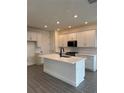 Spacious kitchen with white cabinets, large island, and quartz countertops at 9019 Rothman Ln, Lakewood Ranch, FL 34240