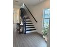 Modern staircase with black railings and gray tile flooring at 9019 Rothman Ln, Lakewood Ranch, FL 34240