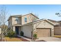 Two-story house with beige exterior, two-car garage, and landscaping at 10710 Southern Forest Dr, Riverview, FL 33578