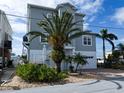 Two-story house with gray siding, palm trees, and a white garage at 13737 Victor Ave, Hudson, FL 34667