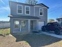 Two-story house with gray siding, a two-car driveway, and a small yard at 27096 Wakefield Dr, Brooksville, FL 34602