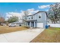 Two-story house with gray siding, a driveway, and a small front yard at 27096 Wakefield Dr, Brooksville, FL 34602