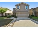 Two-story house with neutral exterior, attached garage, and landscaping at 13752 Reindeer Cir, Hudson, FL 34669