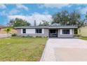 Gray house with white shutters, gravel driveway, and small front yard at 4760 84Th N Ter, Pinellas Park, FL 33781